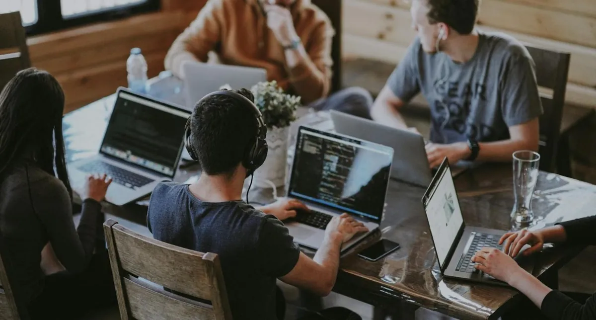 A development team working together at laptops